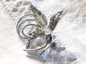 Broche vintage feuille pavée volutes en métal argenté et strass